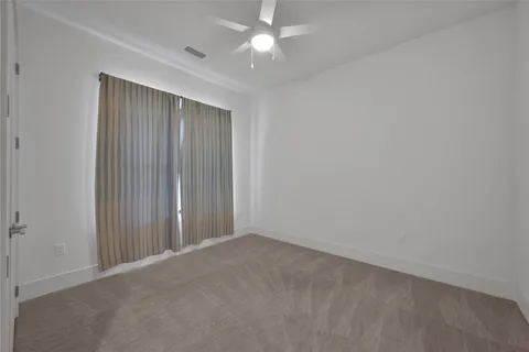an empty room with closet and a ceiling fan