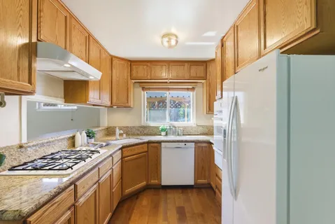 a kitchen with stainless steel appliances granite countertop a sink stove and cabinets