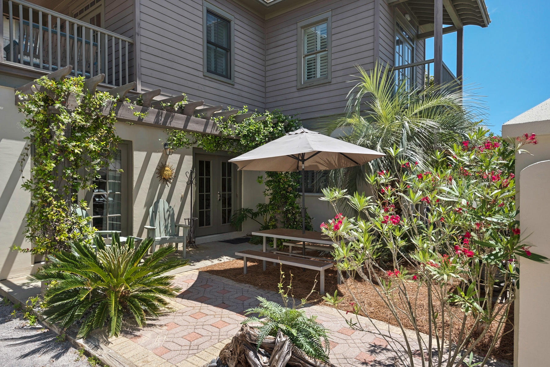 31 Sunset Beach Blvd Inlet Beach Inlet Beach, FL 32461 - Photo 1 of 28 a backyard of a house with table and chairs under an umbrella