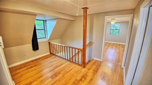 a view of hallway with wooden floor and stairs