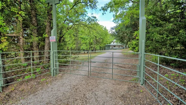 a view of a yard with wooden fence