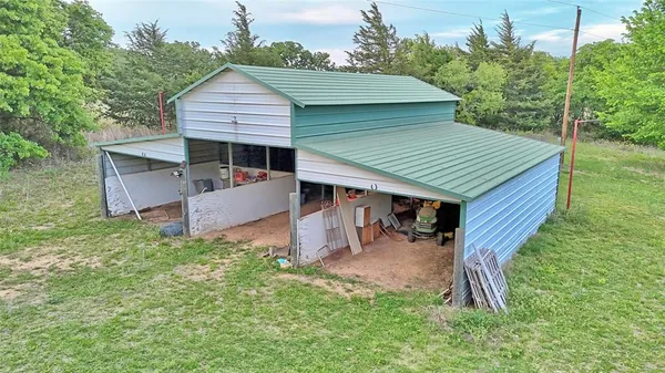 aerial view of a house with a yard chairs and a patio