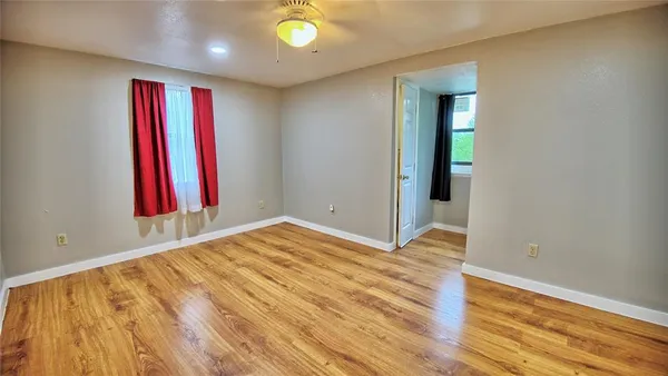 a view of a room with wooden floor and a window