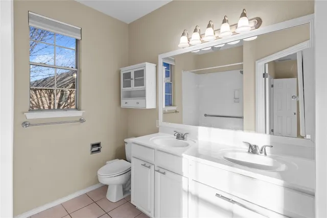 a bathroom with a granite countertop sink a toilet and a mirror