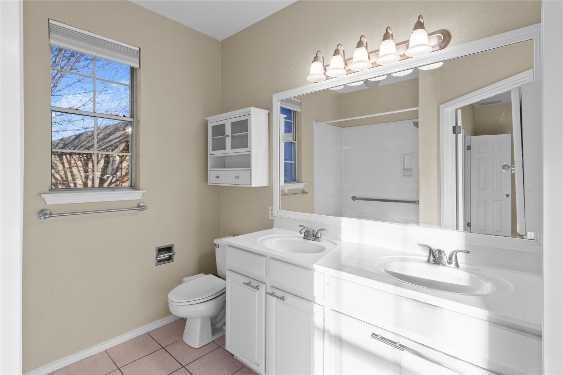 12401 Los Indios Trail, Unit 44 Austin, TX 78729 - Photo 11 of 28 a bathroom with a granite countertop sink a toilet and a mirror