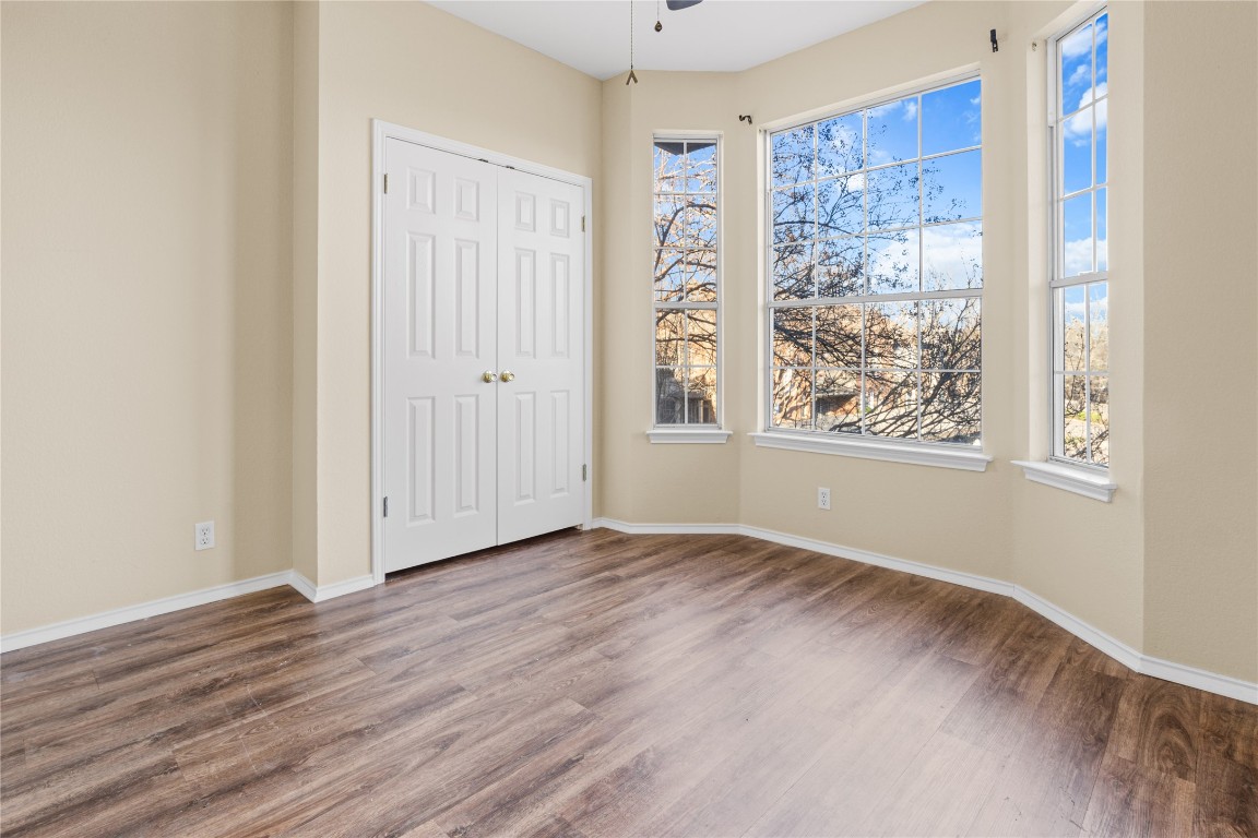 12401 Los Indios Trail, Unit 44 Austin, TX 78729 - Photo 19 of 28 a view of an empty room with wooden floor and a window