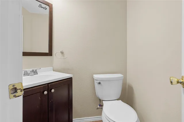 a bathroom with a toilet a sink and mirror