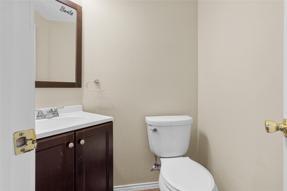 12401 Los Indios Trail, Unit 44 Austin, TX 78729 - Photo 26 of 28 a bathroom with a toilet a sink and mirror