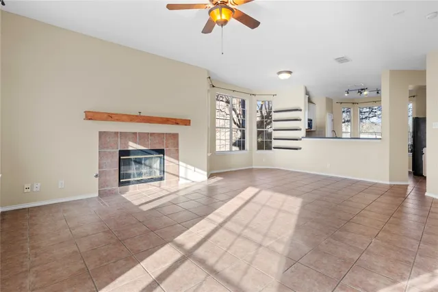 a view of an empty room with a fireplace and a window