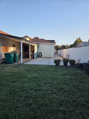 a view of a house with a big yard and large trees