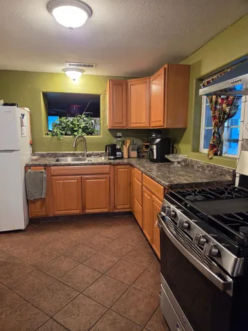 a kitchen with stainless steel appliances granite countertop a stove a sink and a microwave