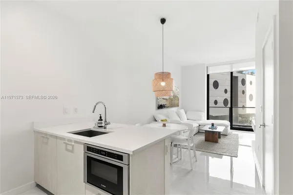 a kitchen with a sink a stove and chairs