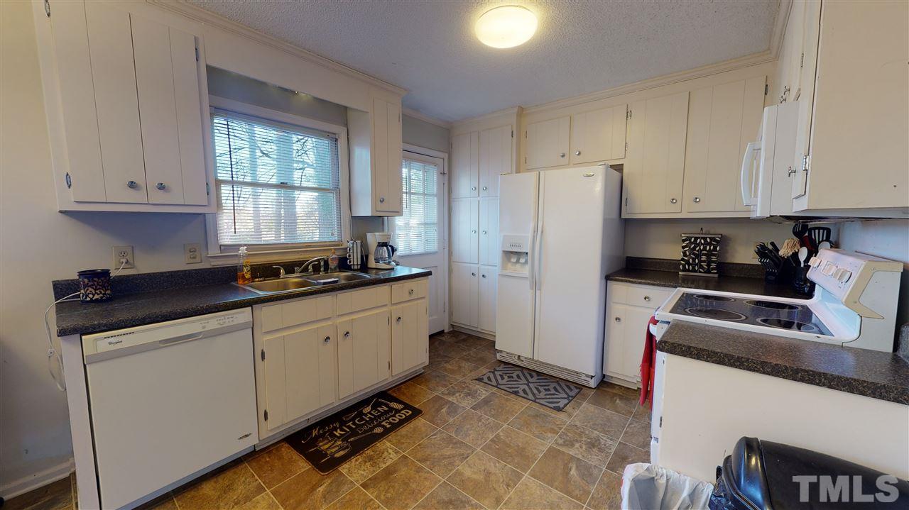 1503 Cole Mill Road Durham, NC 27705 - Photo 8 of 29 a kitchen with granite countertop a refrigerator sink and cabinets