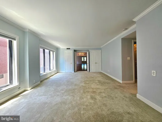 an empty room with windows and closet