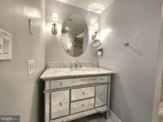 a bathroom with a granite countertop sink a mirror and vanity