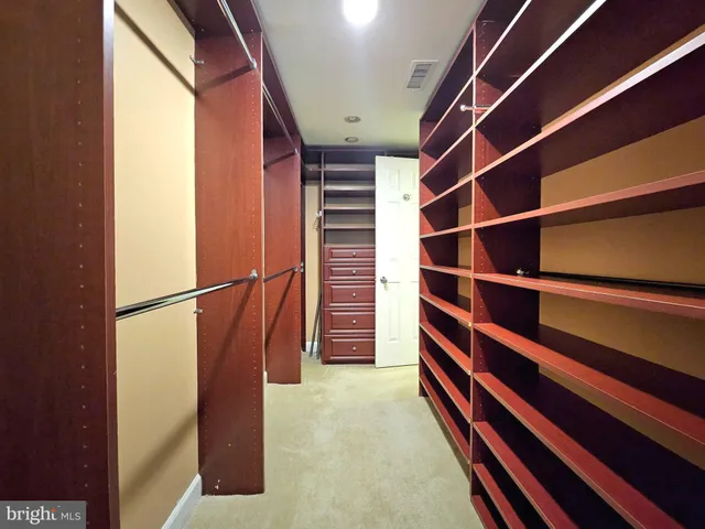a view of walk in closet with clothes and shoes