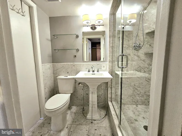 a bathroom with a sink mirror toilet and shower