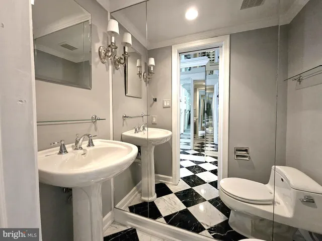 a bathroom with a sink a toilet a mirror and shower