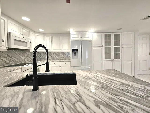 a kitchen with kitchen island a counter top space a sink and appliances