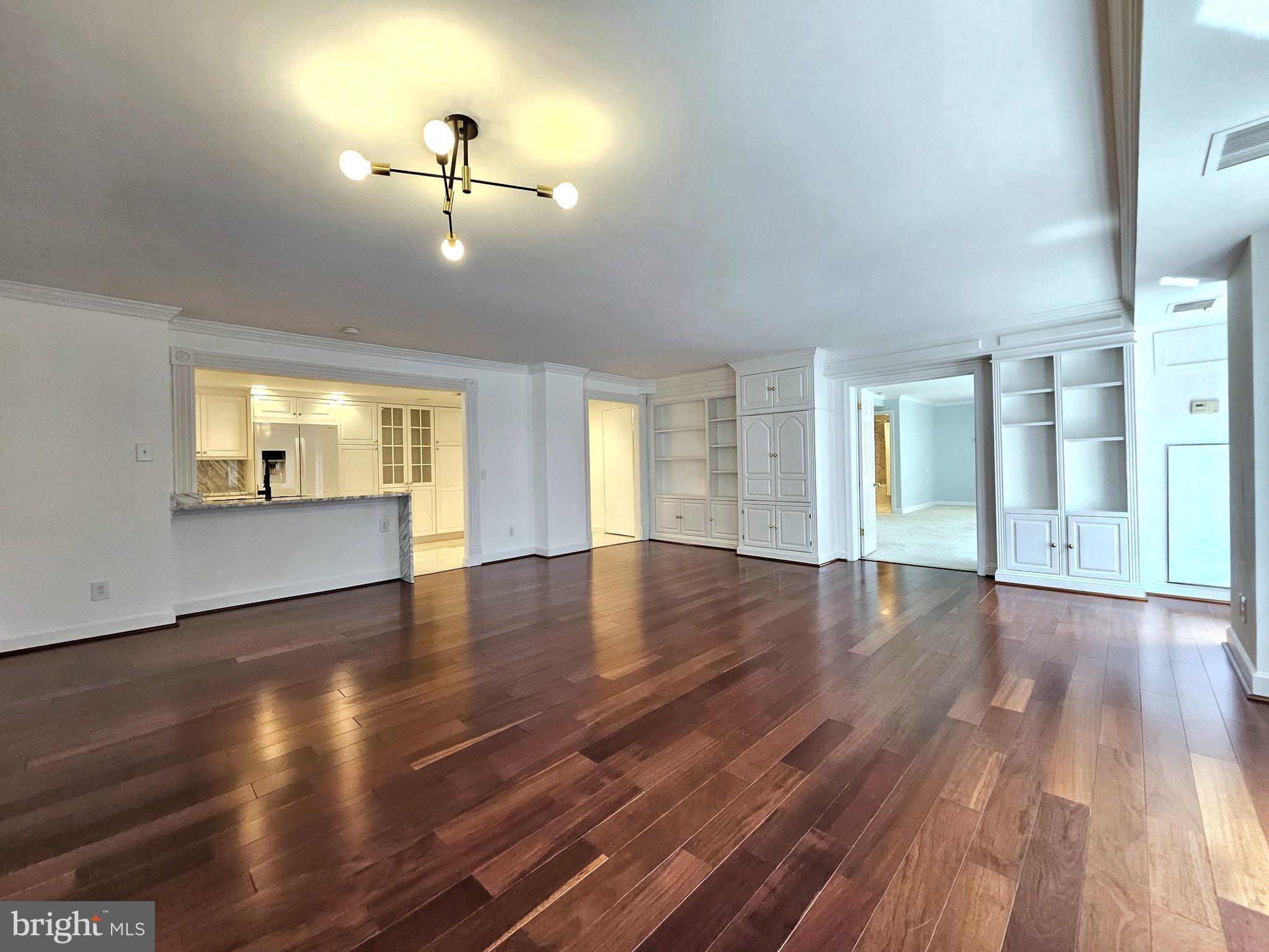 1080 Wisconsin Avenue Northwest, Unit 103/104 Washington, DC 20007 - Photo 6 of 37 a view of an empty room with wooden floor and a window