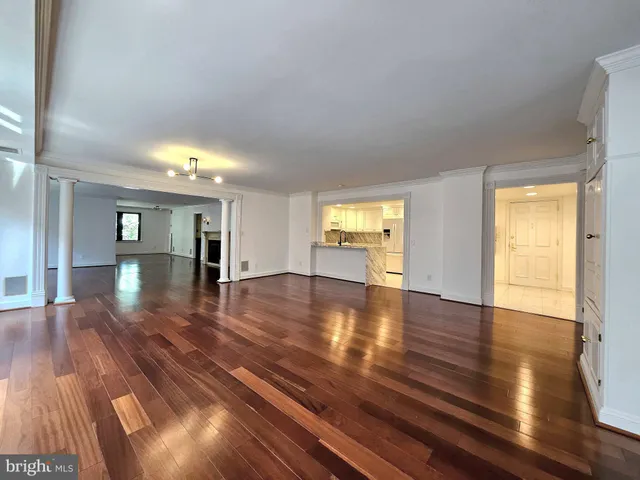 a view of empty room with wooden floor