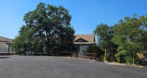 a view of a street with a bench and trees