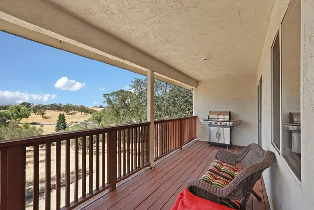 a balcony with wooden floor and outdoor seating
