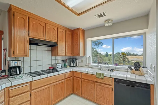 a kitchen with stainless steel appliances granite countertop a sink a stove and cabinets