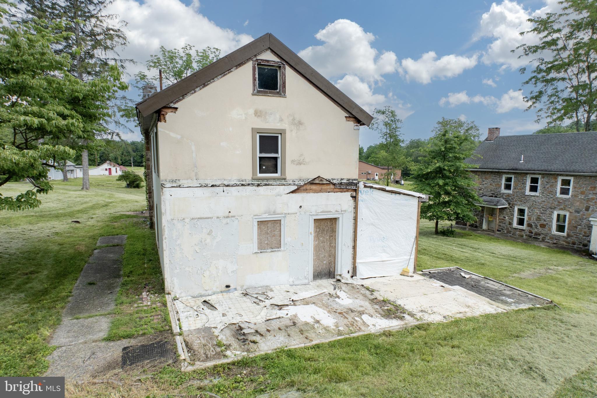 2488 Sanatoga Road Pottstown, PA 19464 - Photo 66 of 92 a view of a white house next to a yard with big trees