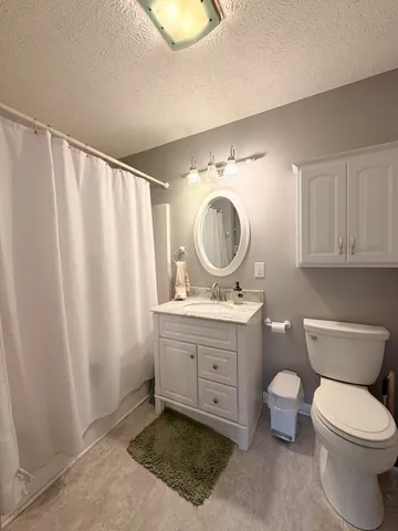 a view of bathroom with a toilet sink and mirror