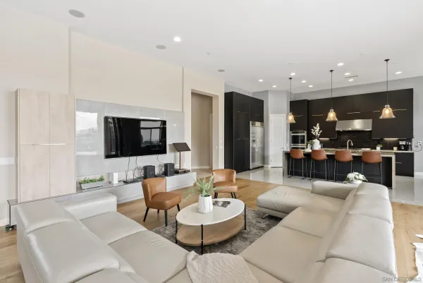 a living room with furniture kitchen and a flat screen tv