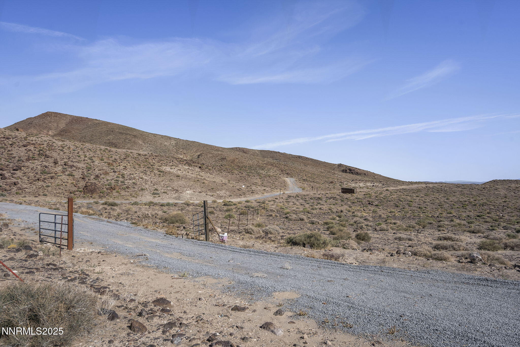 a view of a dry yard with mountains in the background