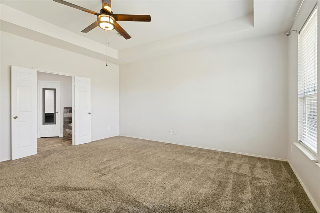 4107 Waverly Road Corinth, TX 76208 - Photo 14 of 30 Double doors from the primary bedroom open to the ensuite bathroom and a neutral color scheme is ready for your personal accents.