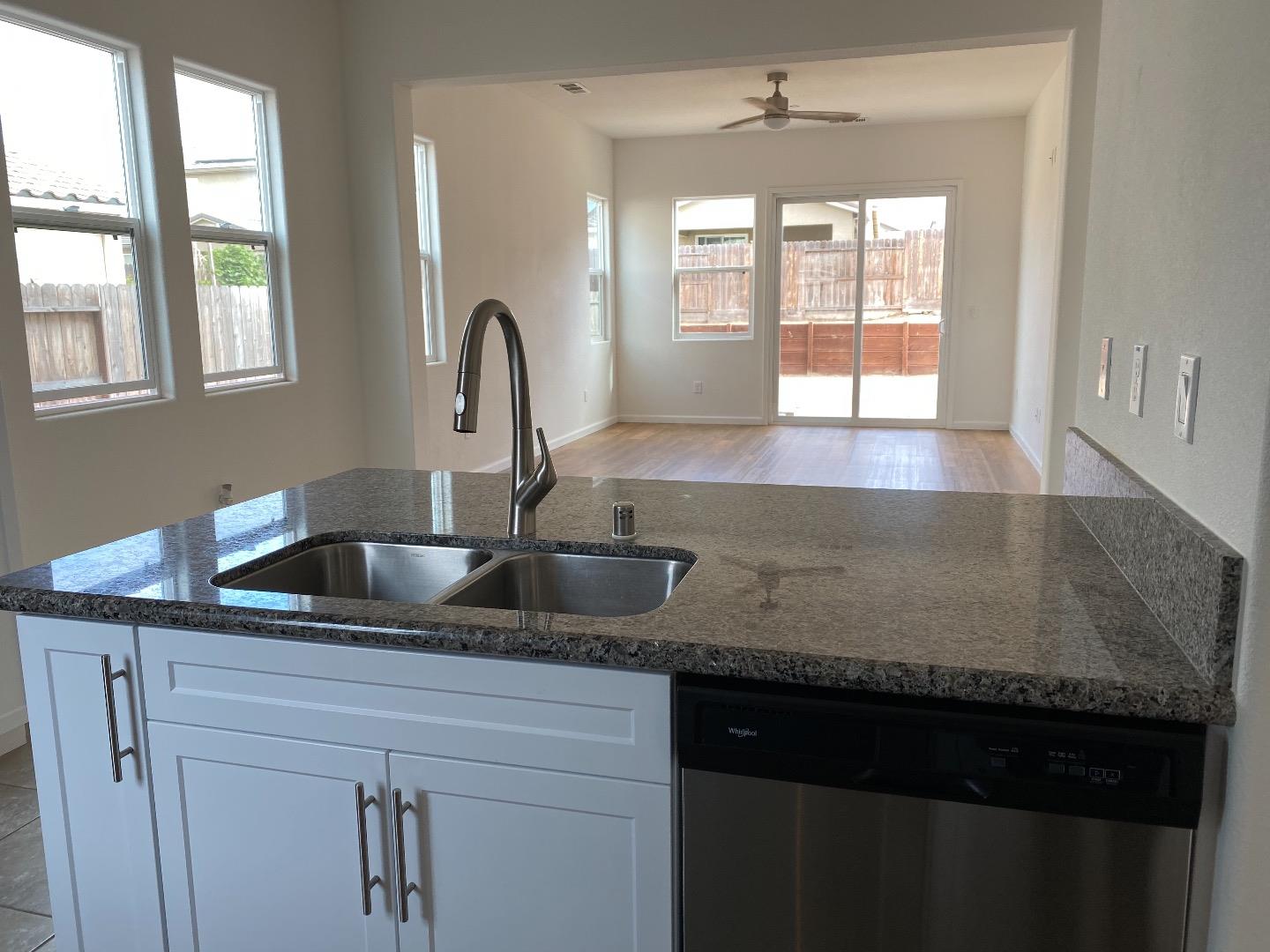 1233 La Colina Street Soledad, CA 93960 - Photo 3 of 10 a kitchen with granite countertop a sink a window and cabinets