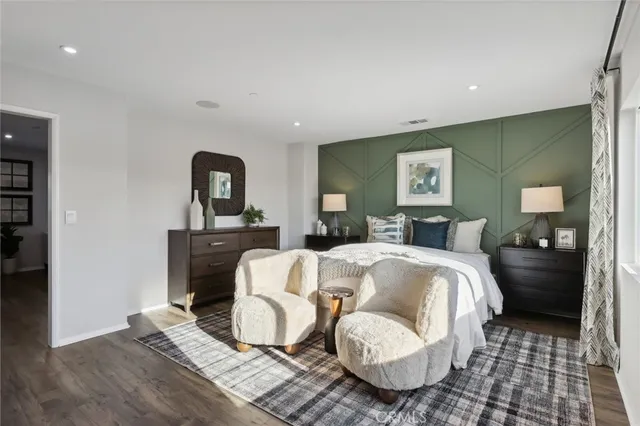 a bedroom with a bed and a mirror on dresser