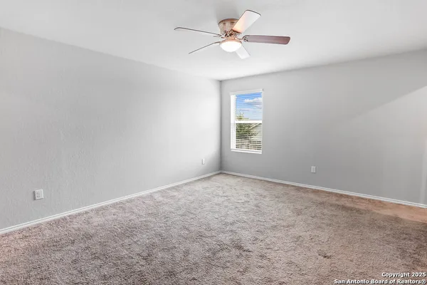 an empty room with windows and fan