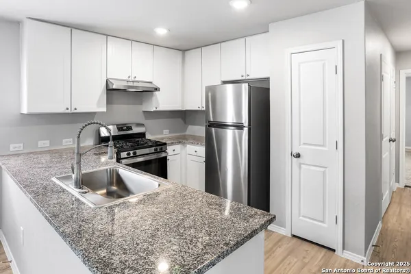 a kitchen with a refrigerator sink and cabinets