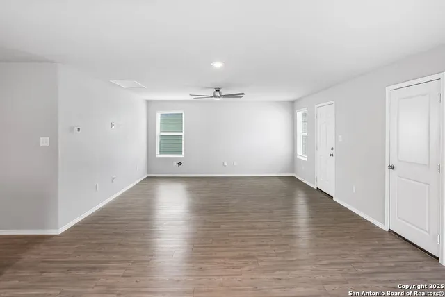 a view of an empty room with wooden floor