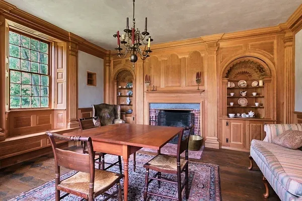 a dining room with furniture a fireplace and a chandelier