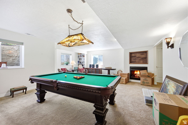 776 Flint Street Layton, UT 84041 - Photo 21 of 41 Spacious recreation room featuring a billiards table with an overhead Tiffany-style light fixture, a built-in fireplace, and recessed windows