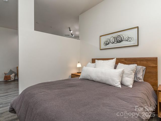 a bedroom with a bed and wooden floor