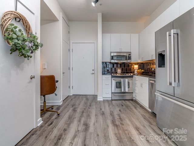 a kitchen with stainless steel appliances granite countertop a refrigerator and a stove top oven