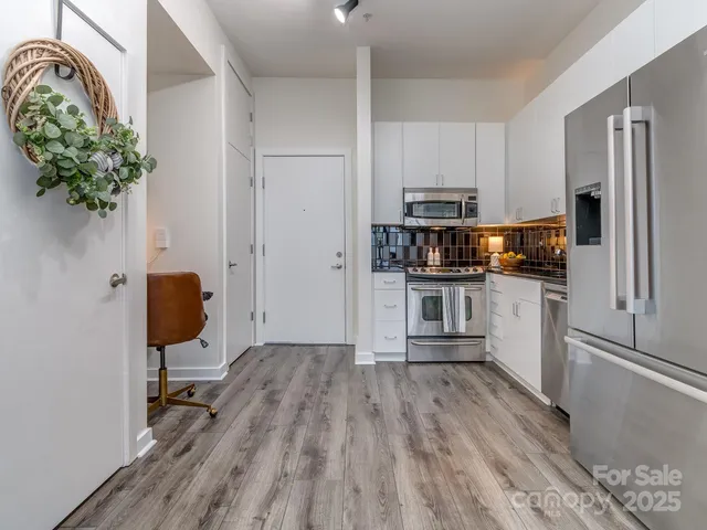 a kitchen with stainless steel appliances granite countertop a refrigerator and a stove top oven