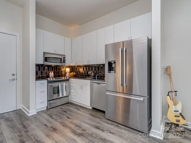 a kitchen with a refrigerator stove and wooden cabinets