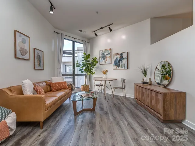 a living room with furniture and a wooden floor