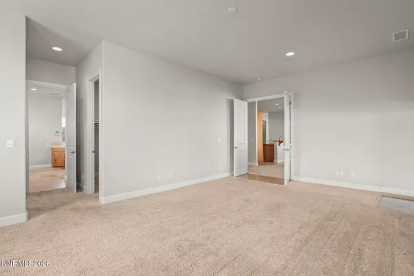 a spacious bathroom with a granite countertop sink a toilet a mirror and shower
