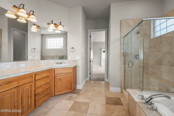 a spacious bathroom with a granite countertop sink a large mirror and a bathtub