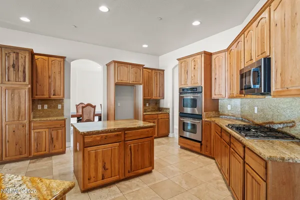 a kitchen with granite countertop a sink and a stove top oven with wooden floor