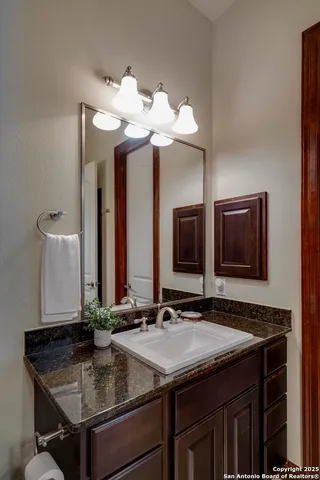 a bathroom with a granite countertop sink and a mirror