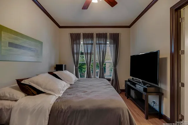 a bedroom with a bed and a flat tv screen on dresser